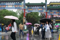 游客雨中游中轴 雨雾古都别样景