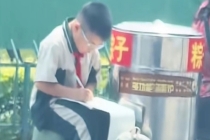 小男孩坐三轮车上写作业刷屏 生活与希望同在