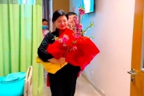 奶奶手拿桃枝接刚出生的宝宝回家 穿着得体脸上洋溢着笑容